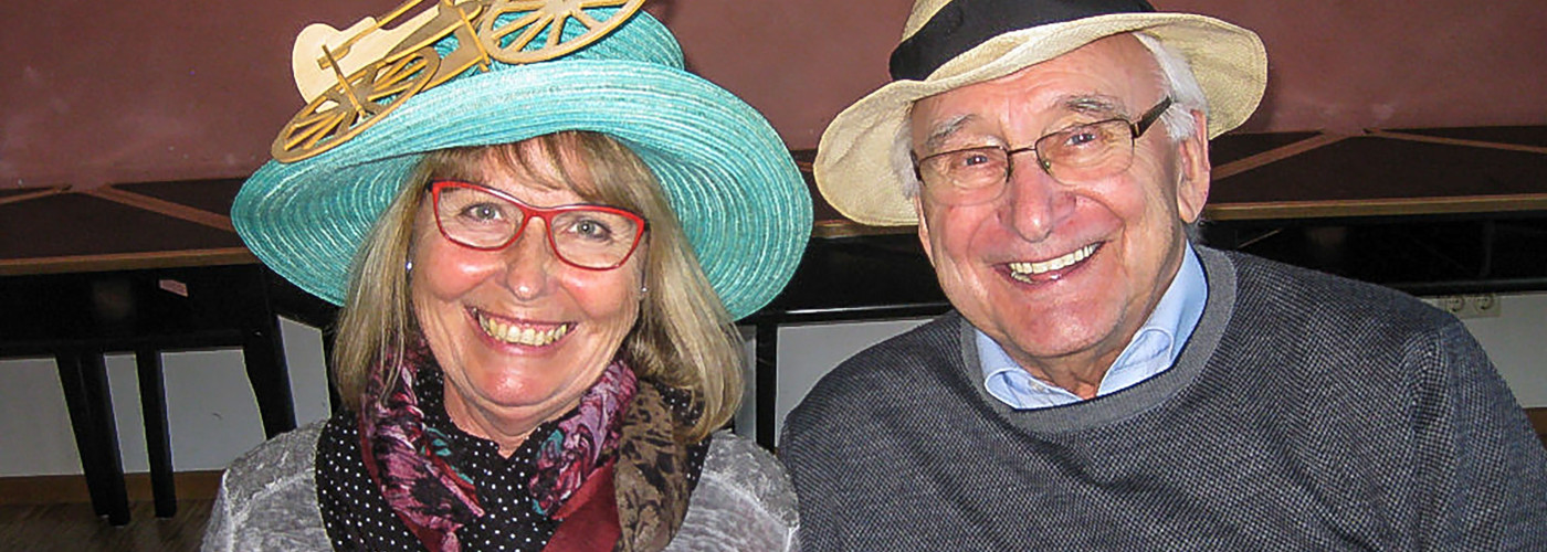 Zwei Senioren nebeneinander, die Frau, links, trägt einen türkisfarbenen Hut, der Mann, rechts, einen hellen Strohhut.