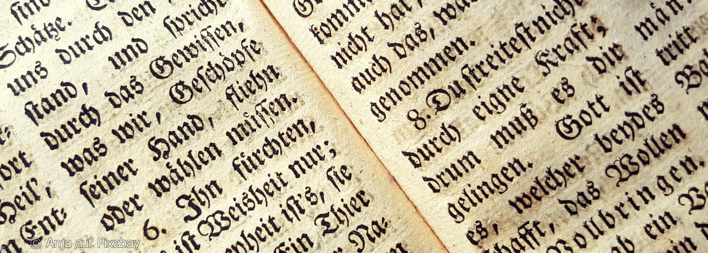 Nahaufnahme einer aufgeschlagenen Bibelseite mit Frakturschrift